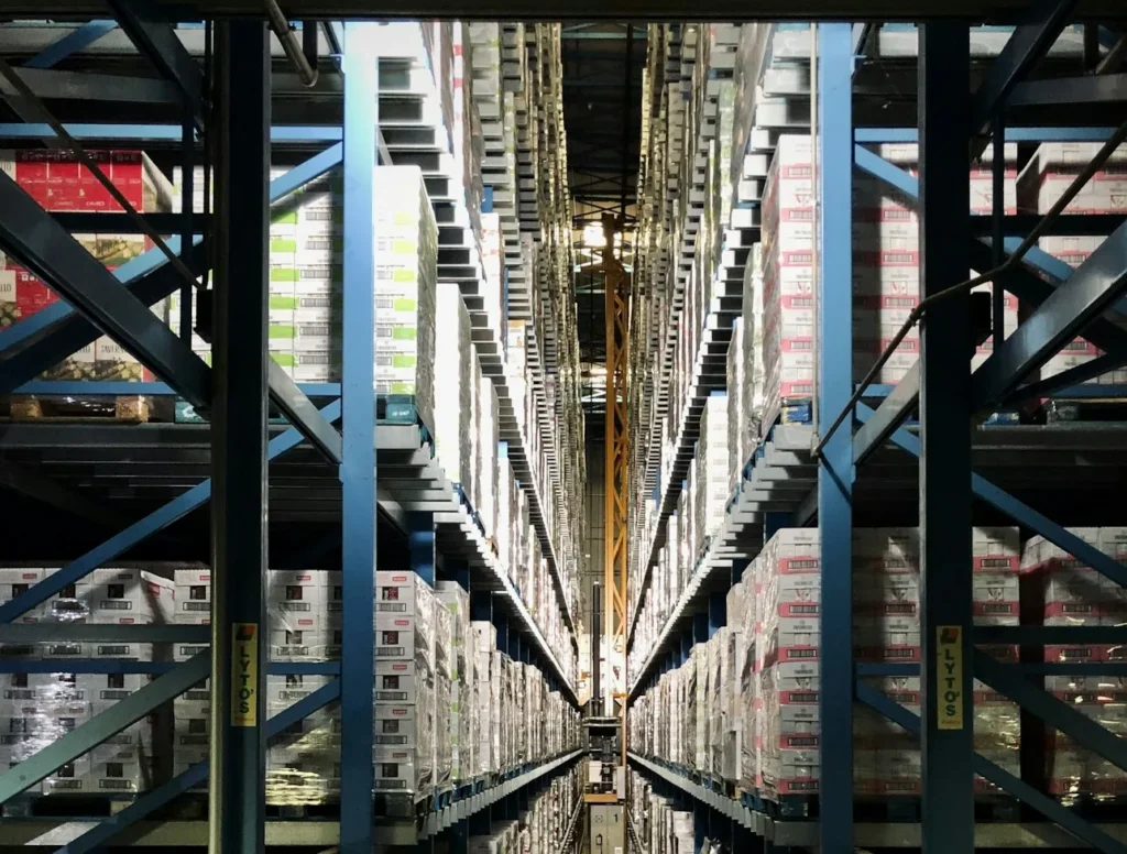 High-bay automated-style warehouse aisle representing inventory and COGS tie-out
