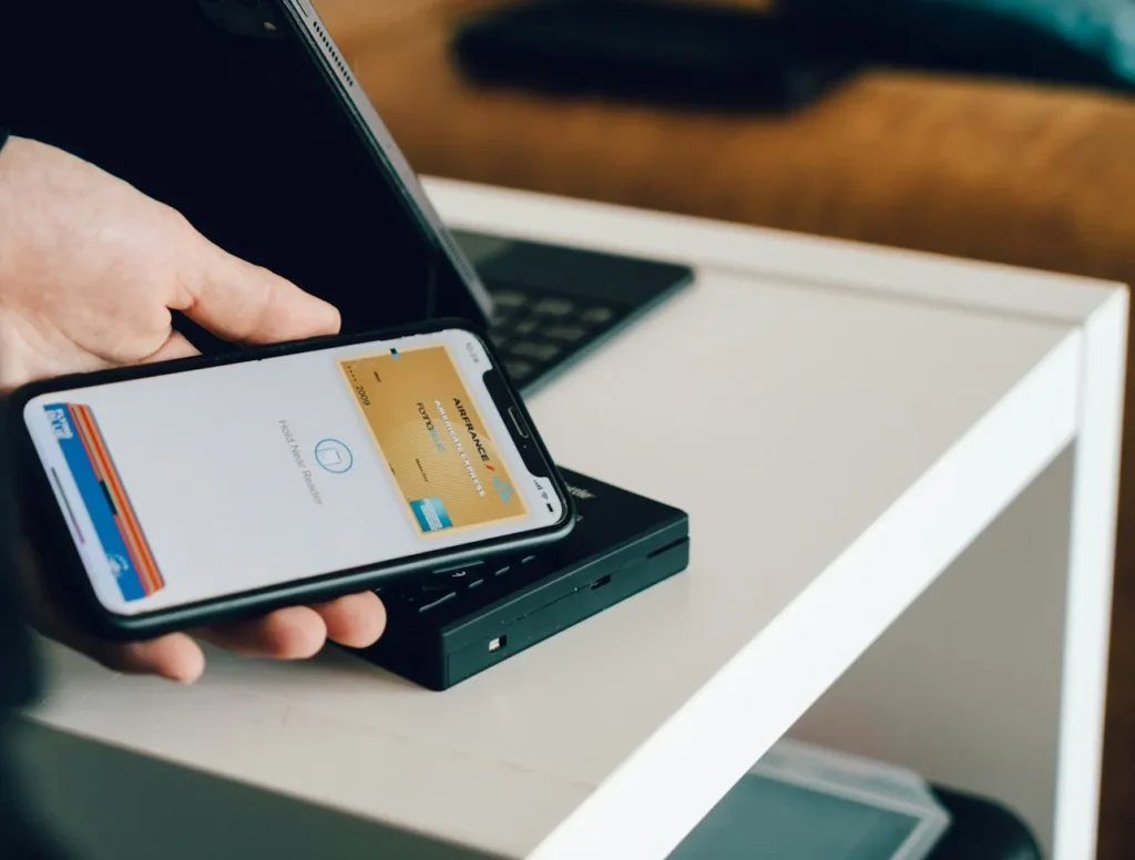 Smartphone contactless payment on a card reader representing marketplace payouts and settlements